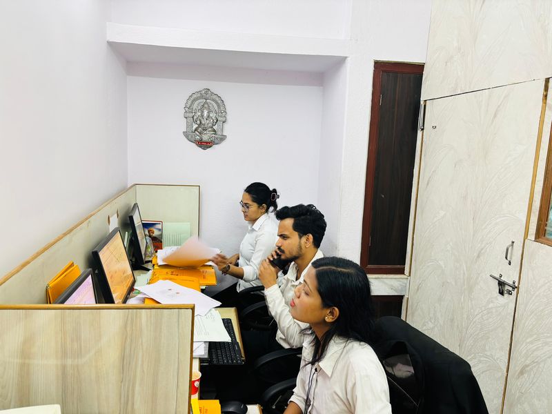 The client care team at a shared workstation, one member on a call.